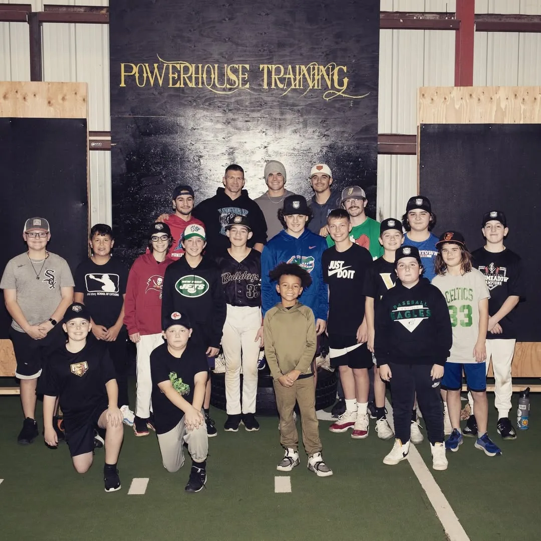 Coach working with athletes in the batting cage